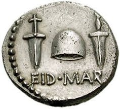 A silver coin bearing the words 'EID MAR' and a hat.