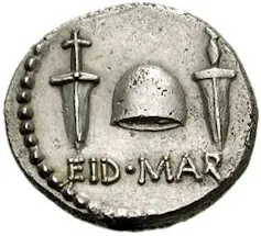 A silver coin bearing the words 'EID MAR' and a hat.