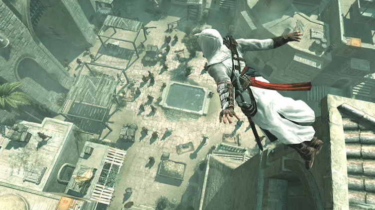 Medieval assassin jumping off a building with a marketplace below.