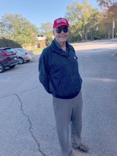 A smiling man wearing a Make America Great Again cap.