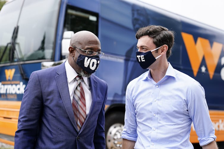 Rev. Raphael Warnock and John Ossoff talk on a campaign stop.