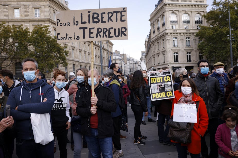 Protestors on the streets of Paris hold a sign reading 'for freedom, against terror'.