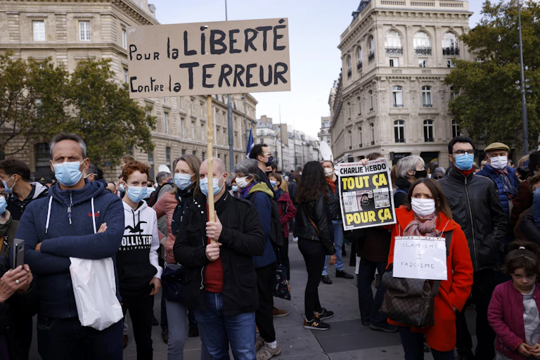 Protestors on the streets of Paris hold a sign reading 'for freedom, against terror'.