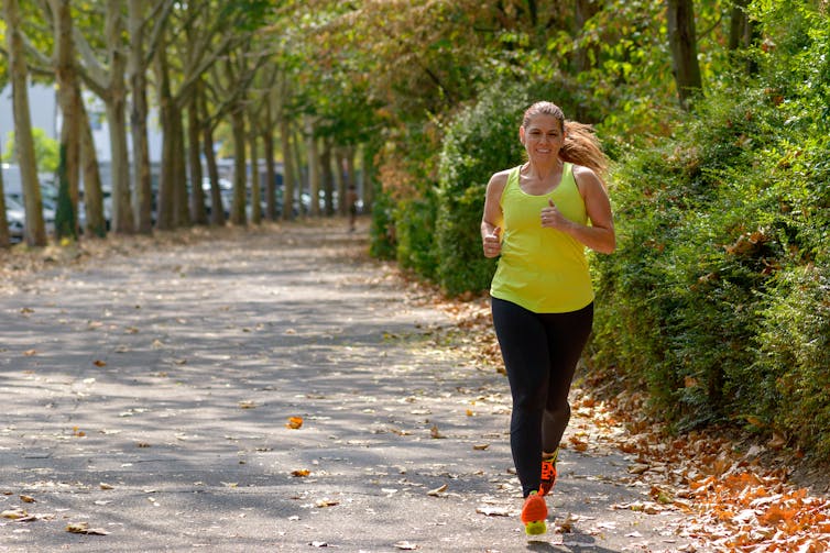 A woman runs in the park.