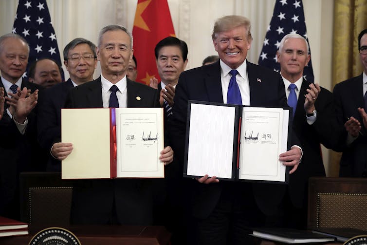 Donald Trump, holding the Phase One trade agreement signed with Chinese Vice Premier Liu He on January 15 2020.