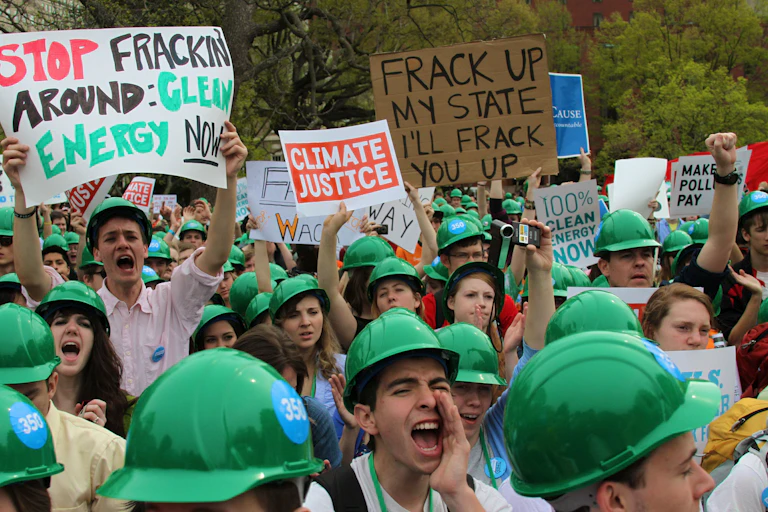 Protesters shouting, holding anti-fracking signs
