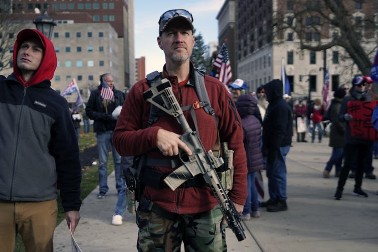 A man carries an assault rifle.