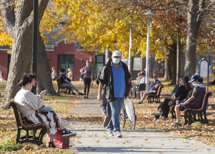 People walk through a park in autumn