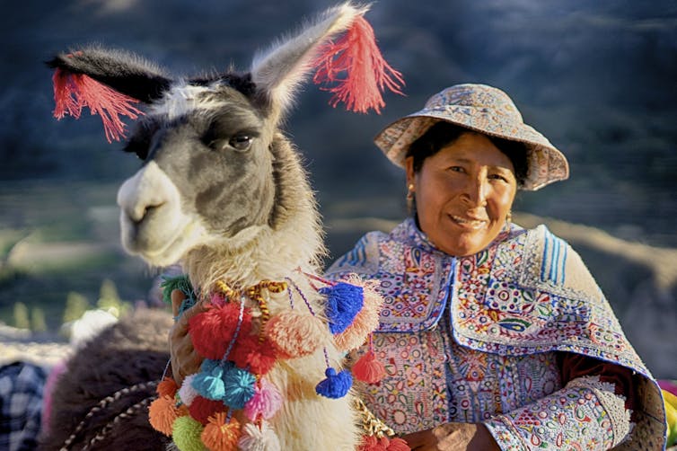 Woman standing next to llama