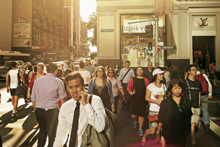 People crossing busy city intersection.