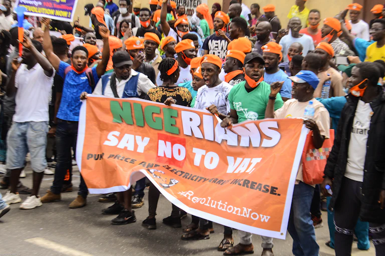 Members of the Revolution Now group, mostly in yellow caps, holding a banner demanding for better governance in Nigeria during a protest in Lagos to mark the country's 60th Independence Day in October 2020.