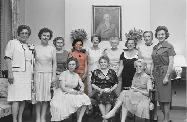 Black and white group photo of the 1960 female congressional class with Patsy Mink in color