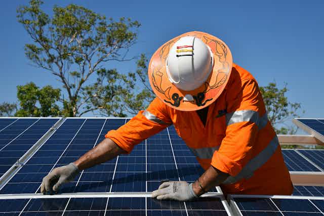 Worker installing solar panels in Daly River, Northern Territory.
