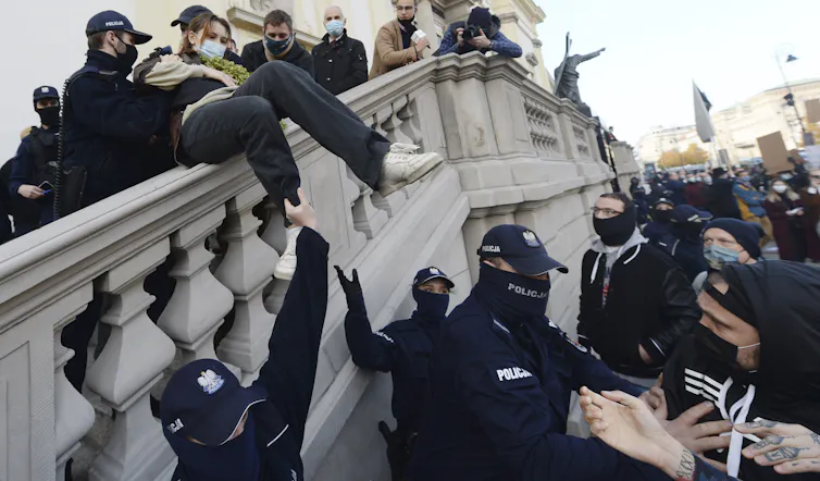 Police and far-right militia remove a young Polish protester from a church.