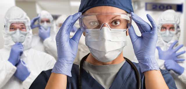 nurses in goggles and suits