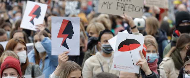 Women carrying signs march in the Warsaw streets.