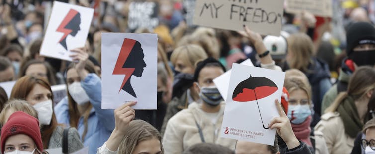 Women’s rights activists with posters of the Women’s Strike symbol protest in Warsaw, Poland, in October 2020 against a further tightening of Poland’s already restrictive abortion laws