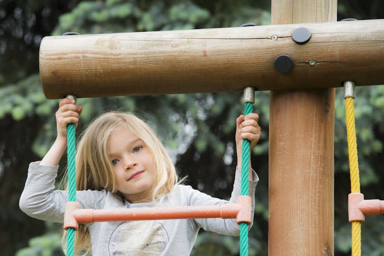 A girl on play equipment.