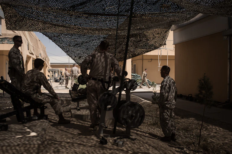 Marines in fatigues at an outdoor gym, photographed from behind