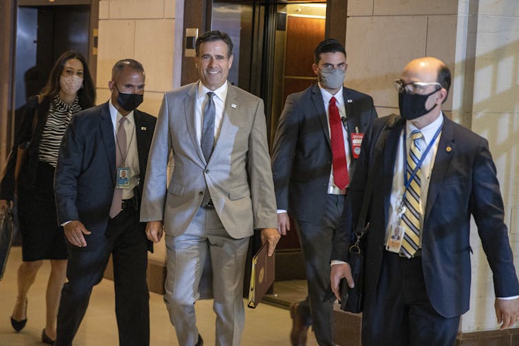 Ratcliffe walks with several other people in the US Capitol.