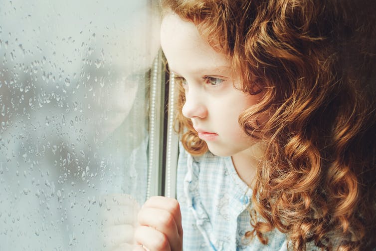 A girl looks out of a window.