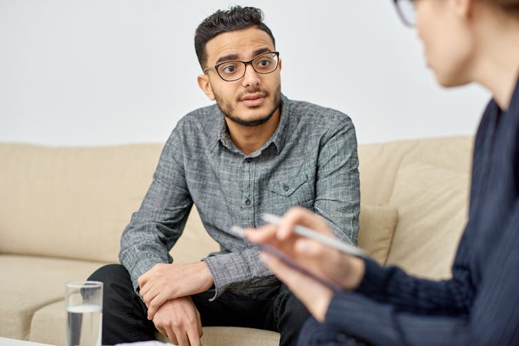 A young man speaks with a psychologist.