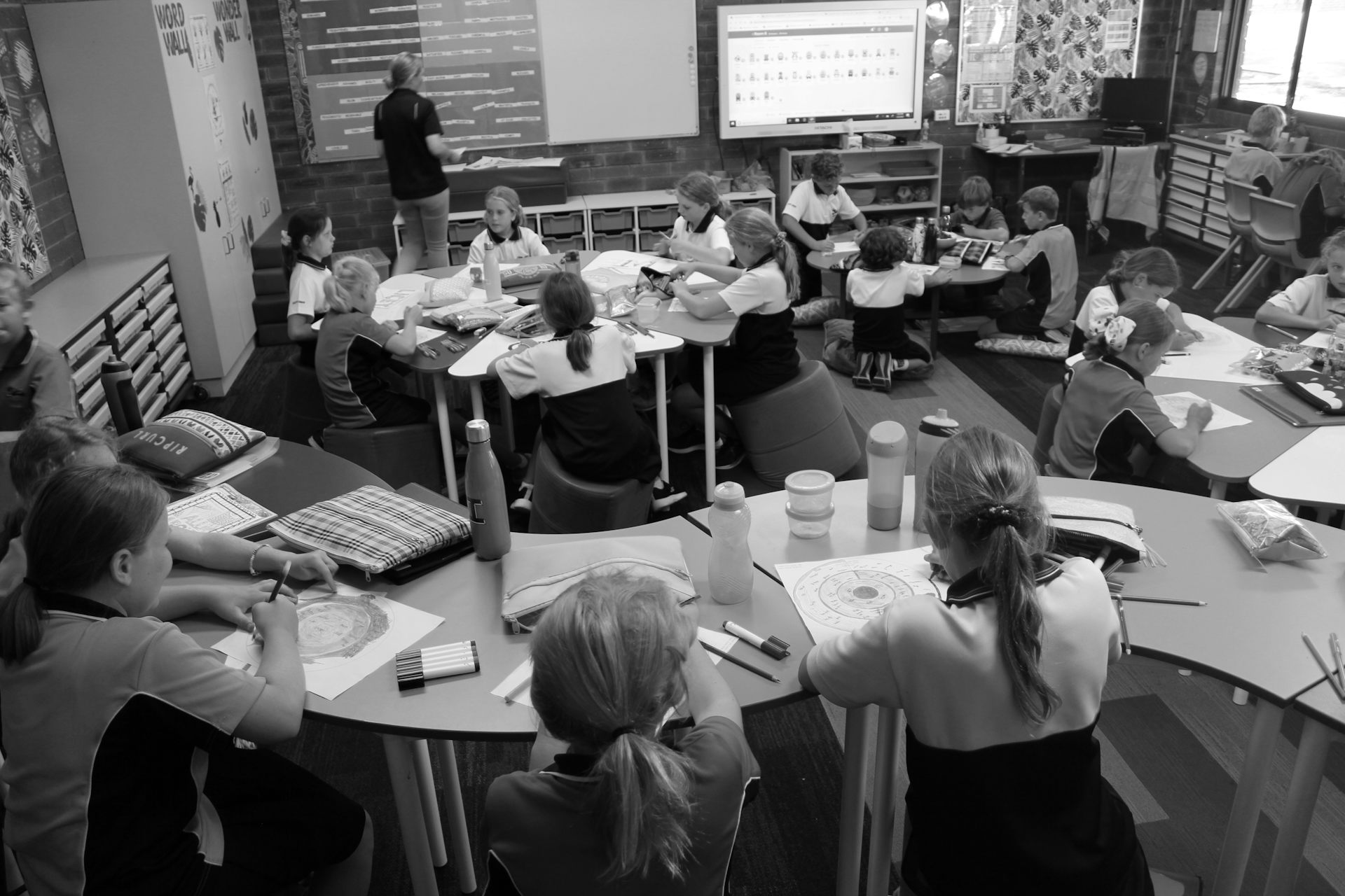 Students in a classroom with different furniture options like ottomans, and no 'front' of the class.