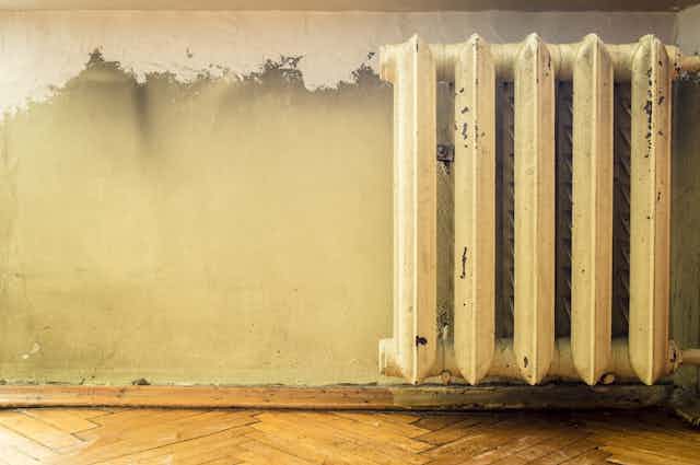 Old heater against peeling wall