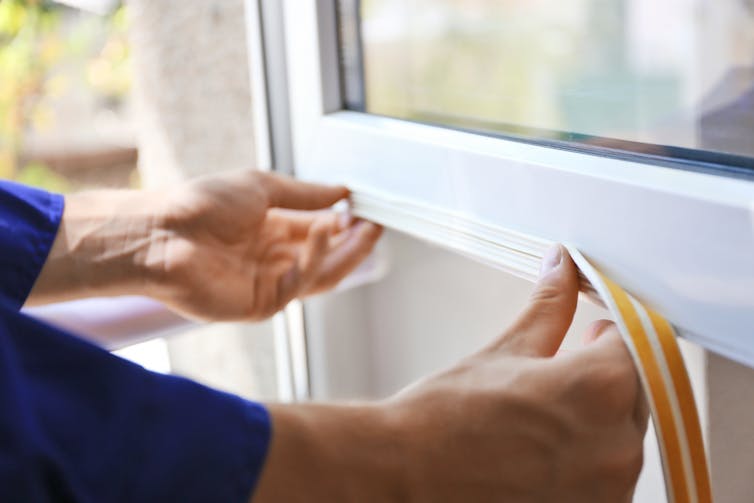 Person applies seal to window