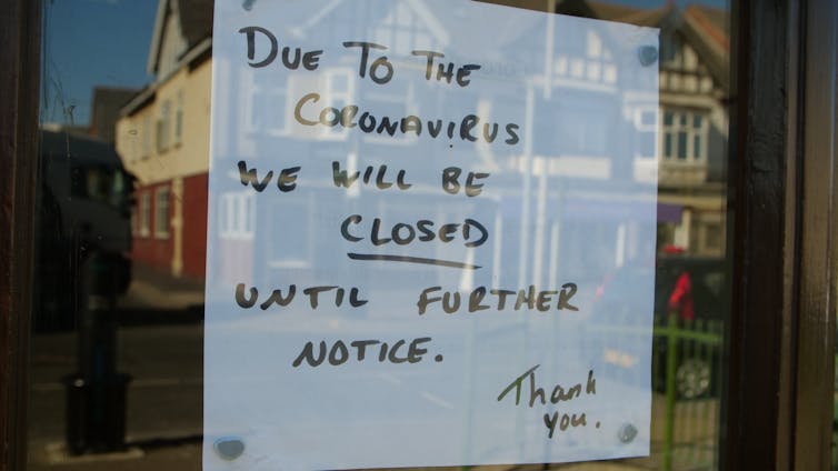 A cafe sign states it is closed due to coronavirus.