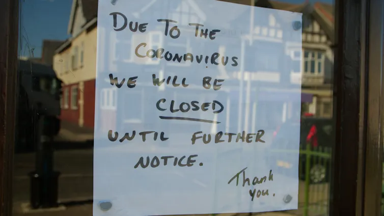 A cafe sign states it is closed due to coronavirus.