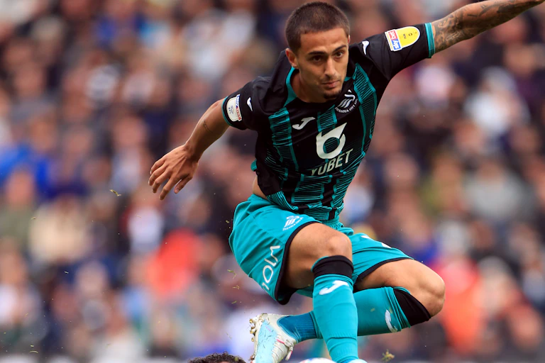 Two footballers battle for the ball.