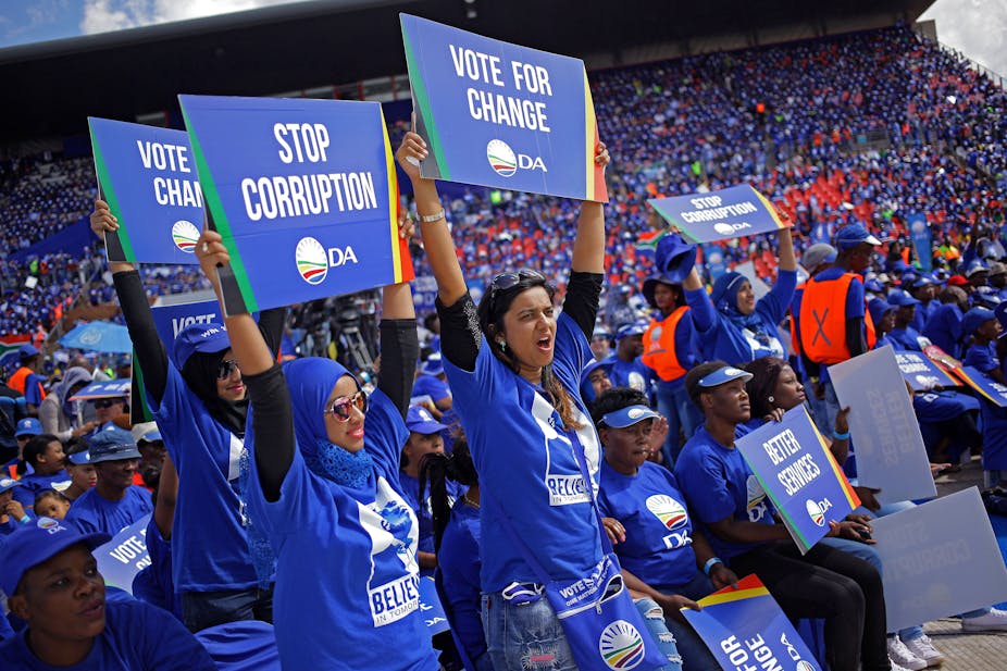 A large crowd of Democratic Alliance supporters clad in blue T-shirts carry placards calling for an end to corruption