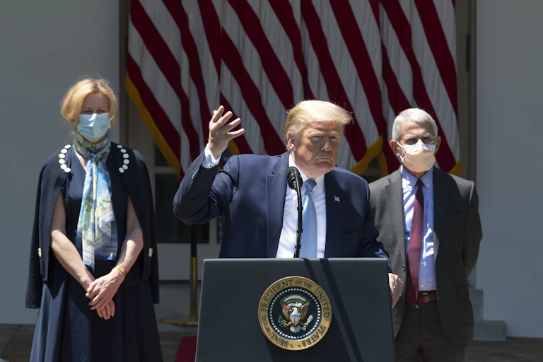 Donald Trump flanked by scientists Deborah Birx and Anthony Fauci.