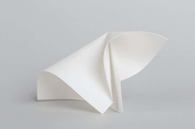 A piece of paper with curved folds forming an origami