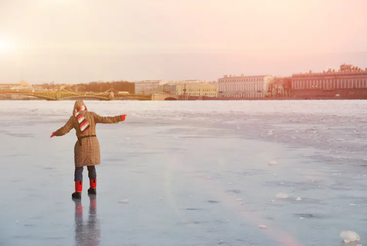 A woman balances on a frozen river