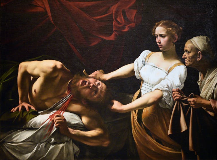 Judith tentatively slices off Holofernes' head.