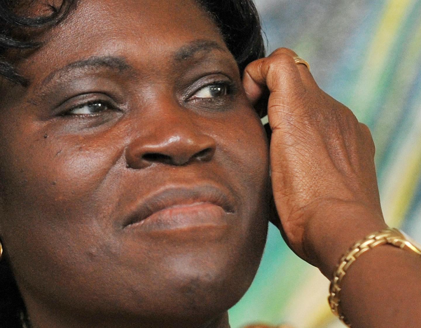 A close-up of Simone Gbagbo shows her scratching her face.