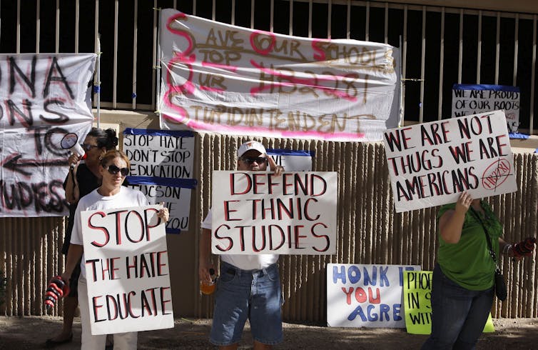 Protesters hold up signs with slogans like 'Defend Ethnic Studies'