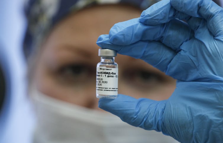 A Russian medic holds up a vial of Sputnik V vaccine.