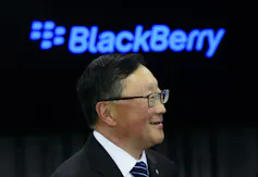 John Chen smiles with a blue Blackberry logo in the background.
