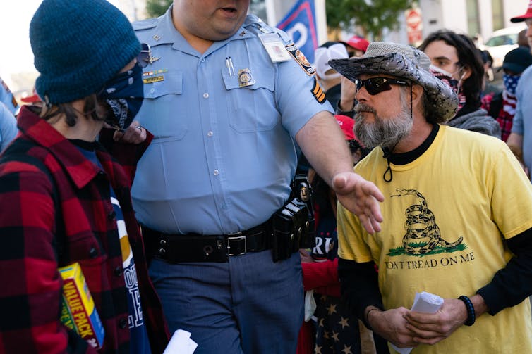 A Georgia state trooper separates Biden supporters from Trump supporters.
