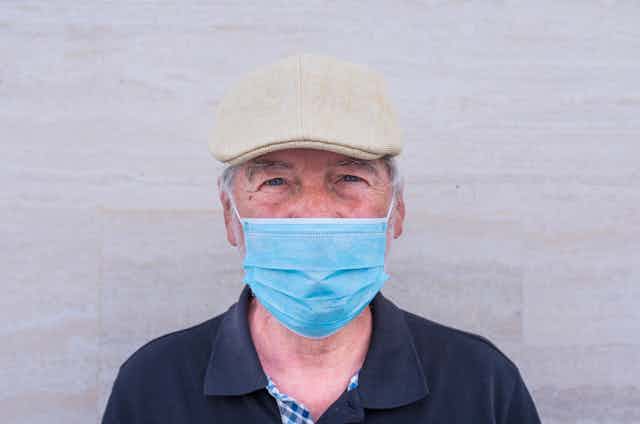 Older man wearing a mask.