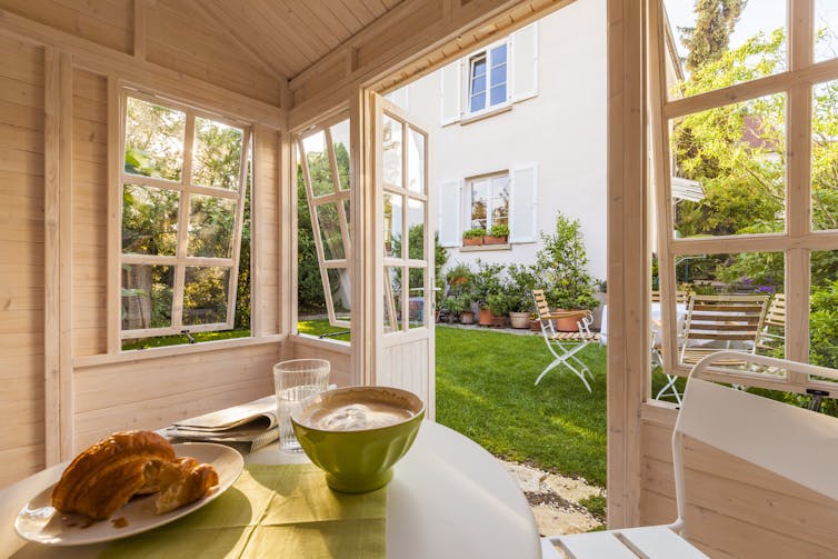 A table with a cooked meal on it inside of a room with doors and windows open.