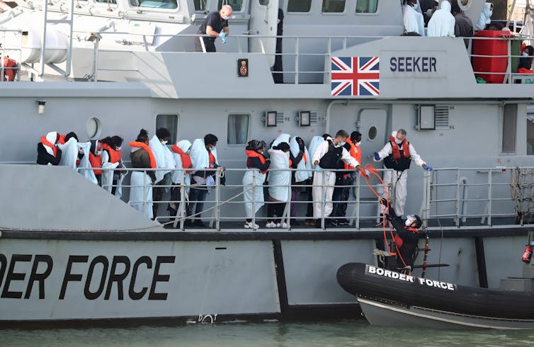 People with life jackets on waiting on a Border Force boat.