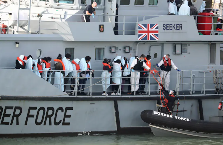 People with life jackets on waiting on a Border Force boat.