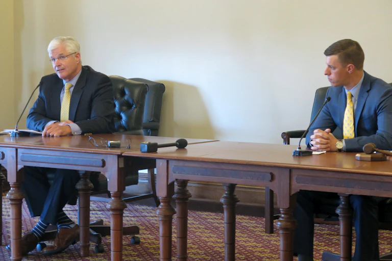 Two men sit at a table