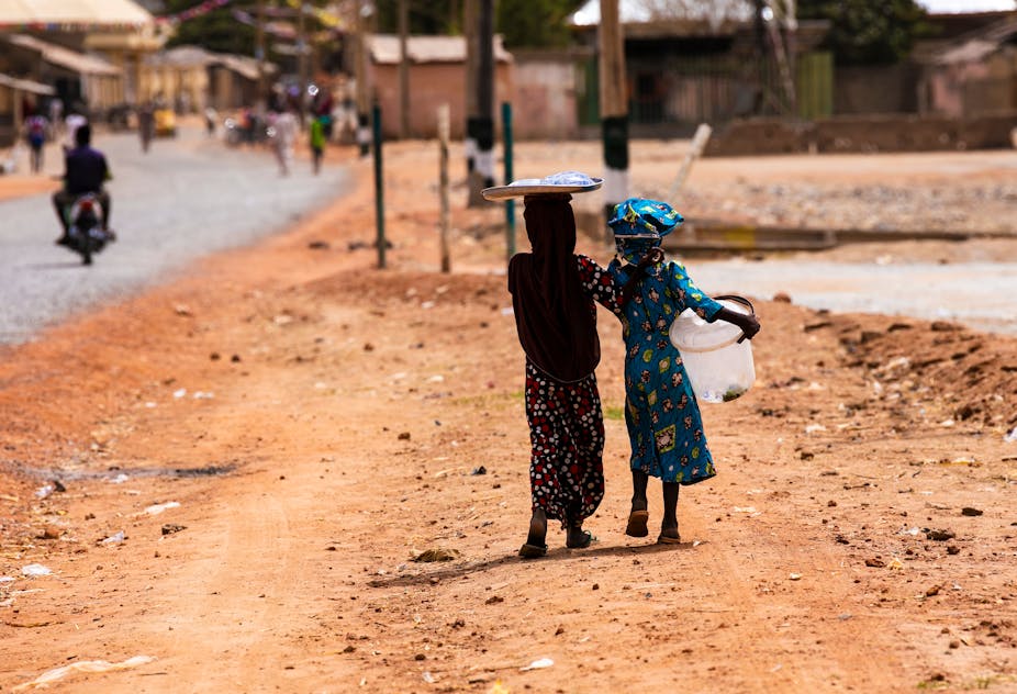 Young girls hawking water on the street in Argungu, Nigeria