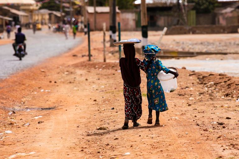 Young girls hawking water on the street in Argungu, Nigeria