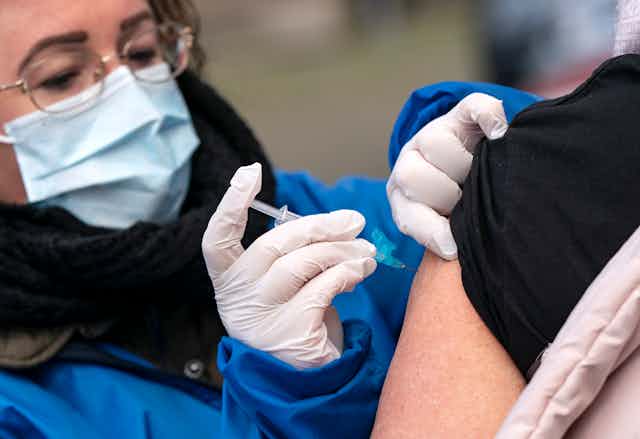 A medic vaccinating a patient.